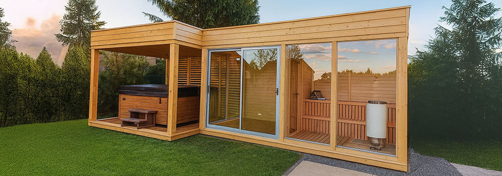 Modern backyard sauna and hot tub cabin with glass doors, natural wood finish, and green lawn.