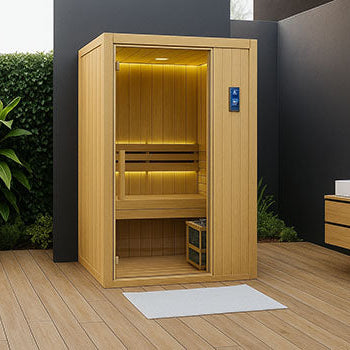 Compact modern indoor sauna with LED lighting in a minimalist garden suite featuring wood decking and sleek dark walls.