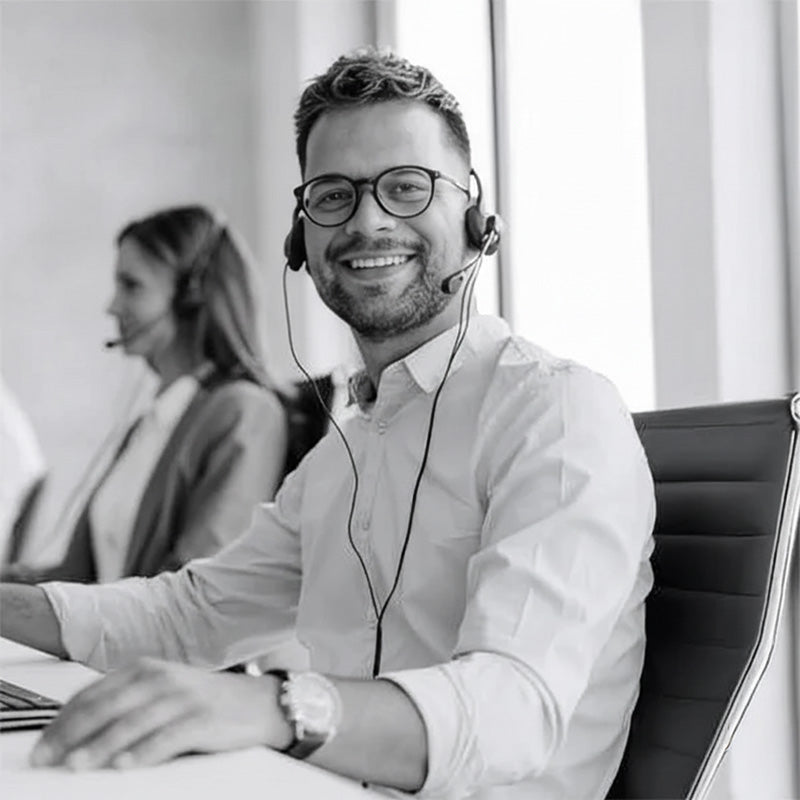Smiling customer support agent with headset providing professional aftercare service in modern office