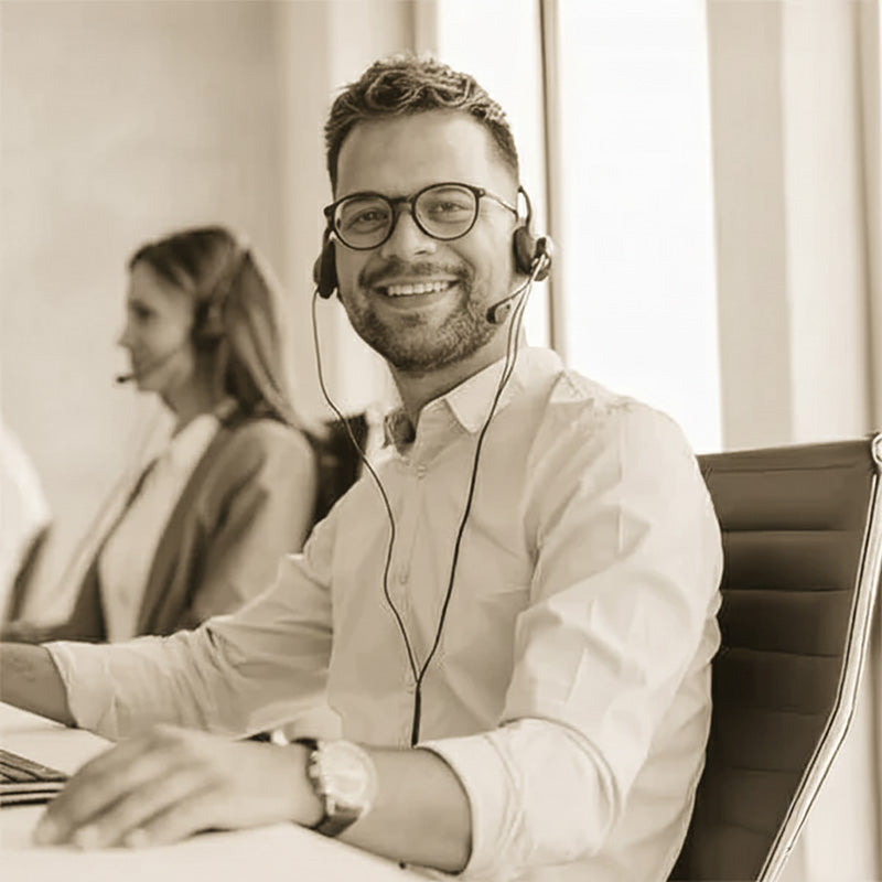 Smiling customer support agent with headset providing professional aftercare service in modern office