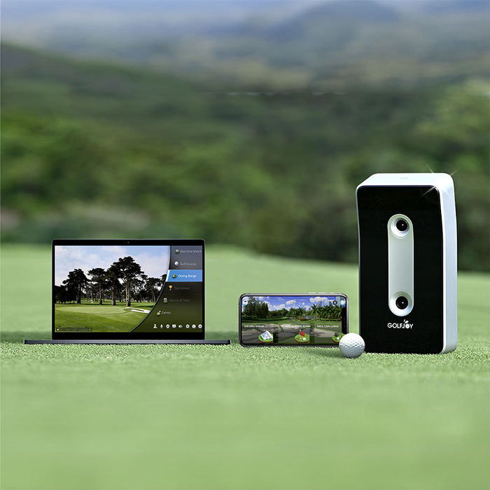 The Golfjoy GDS Plus Launch Monitor set up on a golf course, with a laptop and smartphone displaying the real-time shot data and analysis.