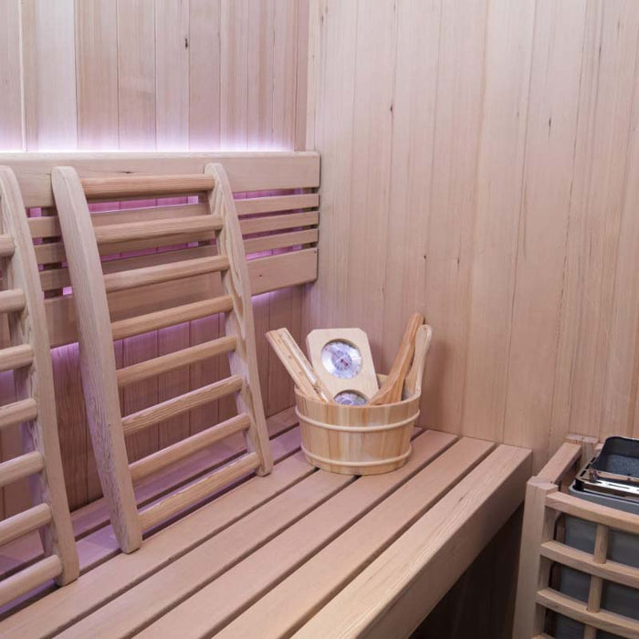 A premium home sauna with soft pink LED lighting, wooden bucket, and thermometer, enhancing your wellness retreat.
