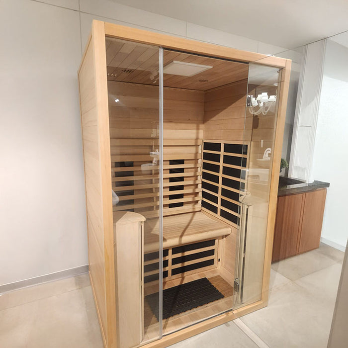 Compact front view of the Jaquar 2-seater infrared sauna in a wooden finish with clear glass door and visible heater grids.