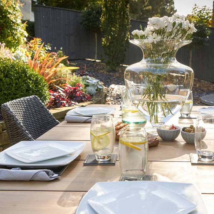 Larissa Outdoor Dining Set with dishes, food and drinks, elegantly displayed on table.
