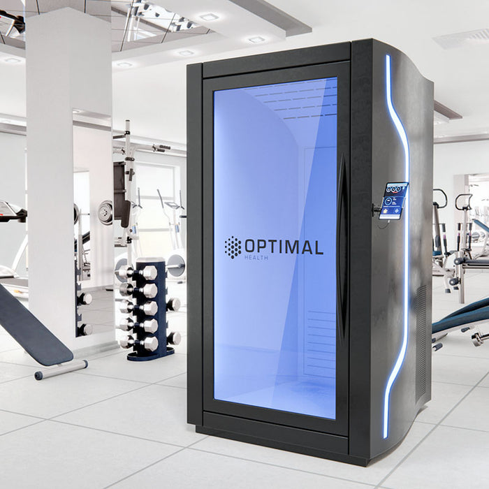 Optimal Health electric cryotherapy chamber in a modern gym, featuring LED lighting, sleek black frame, and blue-tinted glass for advanced cold therapy sessions.