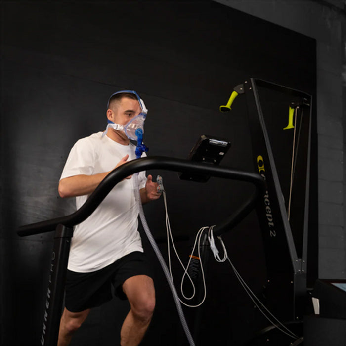 A male athlete runs on a treadmill while connected to the Optimal Health Hypoxic Therapy Machine, simulating high-altitude training conditions.