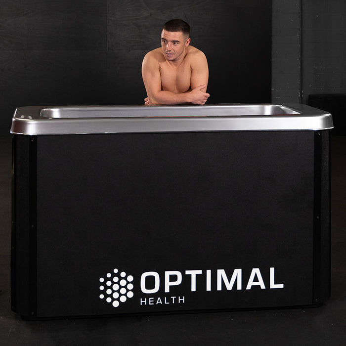 A sportsman leans on the edge of the Optimal Health Ice Bath, enjoying cold water immersion for optimal post-workout recovery.
