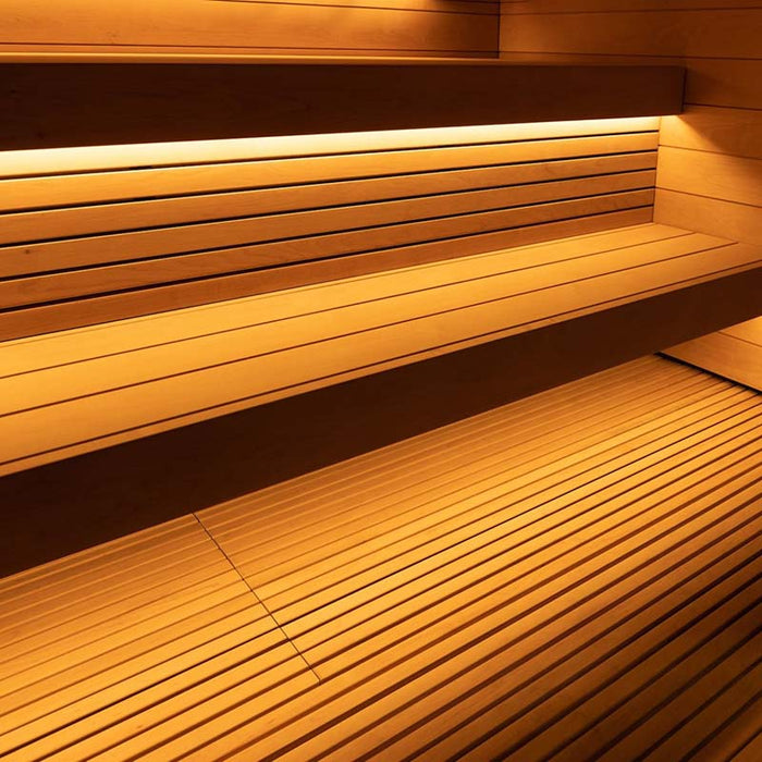 A close-up of the wooden benches and integrated lighting inside the Saunum AirCube Terrace Outdoor Sauna, offering a warm and cosy seating area.