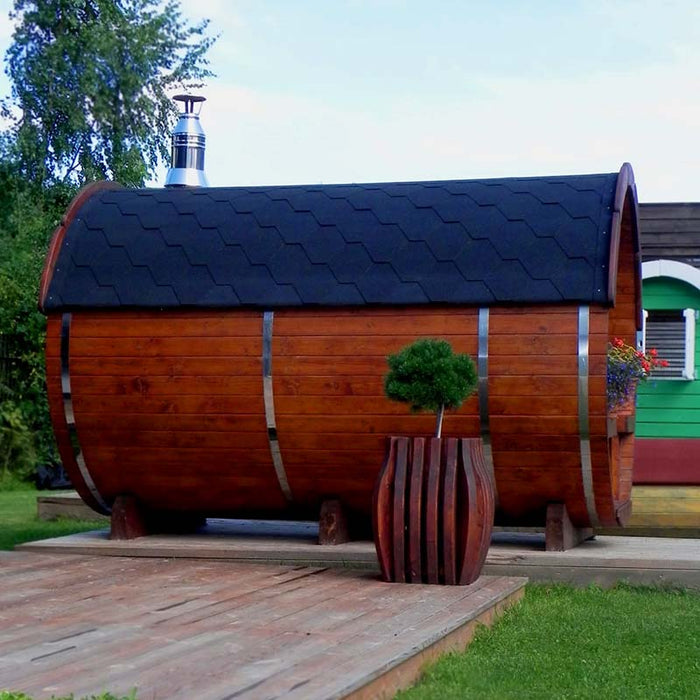 Traditional Sauna Barrel outdoor with a small plant in front.