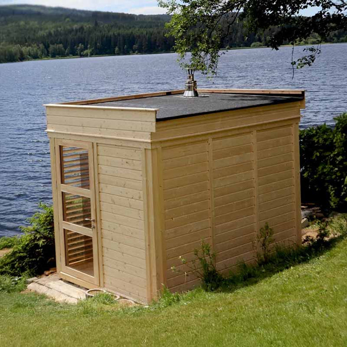 Cosy traditional sauna cube by the water, perfect for a peaceful getaway.
