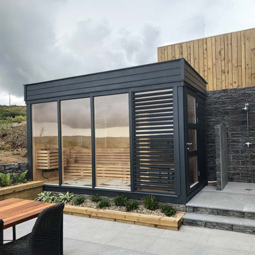 A modern sauna cube with wooden table and chairs.