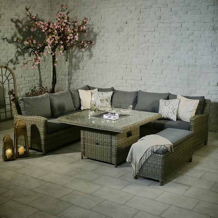 Elegant Wentworth Fire Pit Dining & Lounge Set with square table, perfect for intimate gatherings with its cosy rattan seating and warm lighting.
