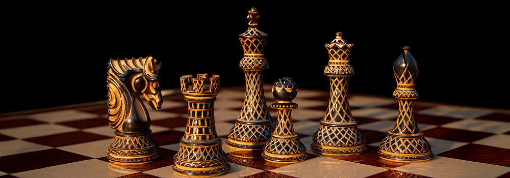 Ornate black and gold chess pieces on a red and cream checkered board with dark background.