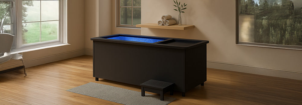Modern black ice bath in elegant bathroom with wood floors and pendant lighting.