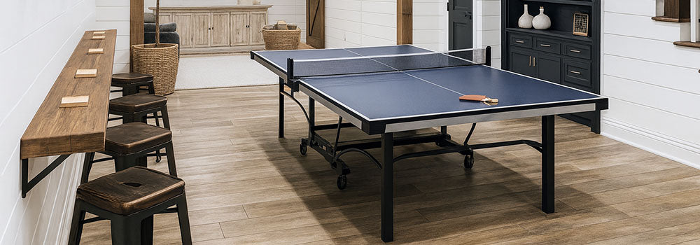blue ping pong table in a stylish farmhouse basement with wood beams, shiplap walls, and modern black accents.