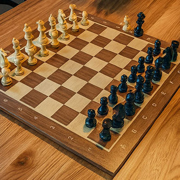 Classic wooden chess set on engraved board over natural grain dining table in ambient modern setting.