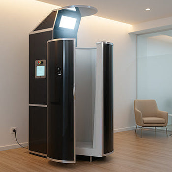 Cryotherapy chamber in a minimalist wellness room with wood flooring and soft lighting.