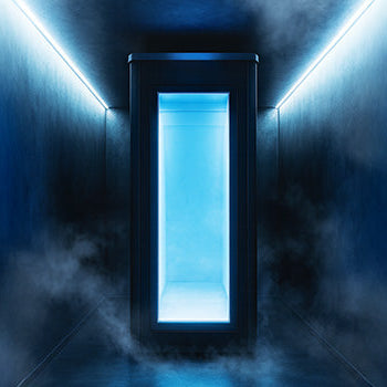 Cryotherapy chamber in a dark hallway with blue LED lighting and swirling cold mist for a futuristic wellness experience.