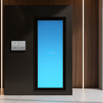 Modern cryotherapy chamber in a luxury home gym with yoga mat, dumbbell, and outdoor garden views.