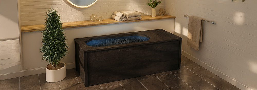 Dark wood ice bath in tranquil spa room with brick wall, potted plant, and soft natural lighting.