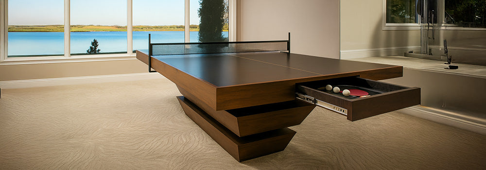 luxury dark wood ping pong table with storage drawer in a lakeside home gym with panoramic window views.