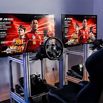 Dual racing simulator gaming setup with racing seats, steering wheels, pedals and monitors for an immersive motorsport gaming experience.