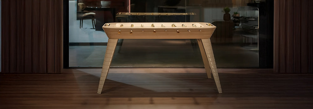 elegant foosball table with gold details under artistic pendant lights in a stylish modern interior.