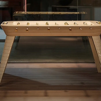 elegant foosball table with gold details under artistic pendant lights in a stylish modern interior.