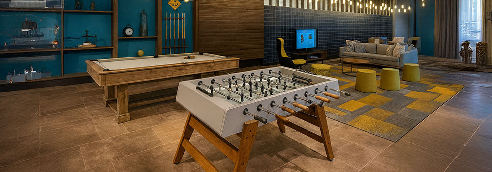 modern foosball and billiards tables in a stylish lounge with wood accents and blue feature wall.