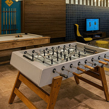 modern foosball and billiards tables in a stylish lounge with wood accents and blue feature wall.