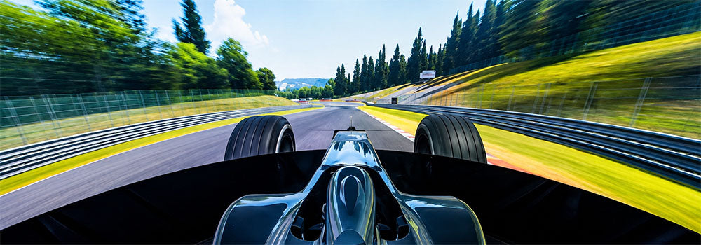 Immersive Formula racing simulator screen view showing an open-wheel race car driving at speed around a realistic motorsport circuit.