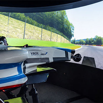 Formula racing simulator with open-wheel cockpit and panoramic curved screen creating an immersive virtual racetrack driving experience.