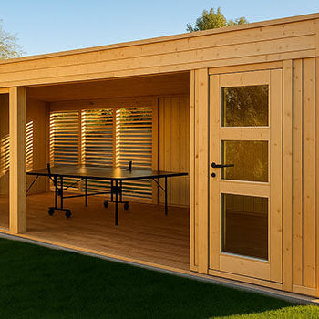 Modern light-wood garden room with open middle space and ping pong table, framed by glass panels and lawn at sunset.