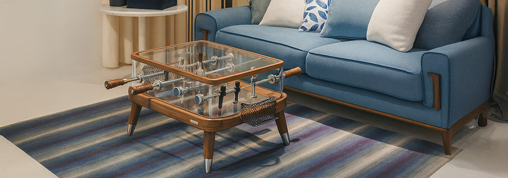 glass-top foosball coffee table with wooden frame in a chic blue living room..