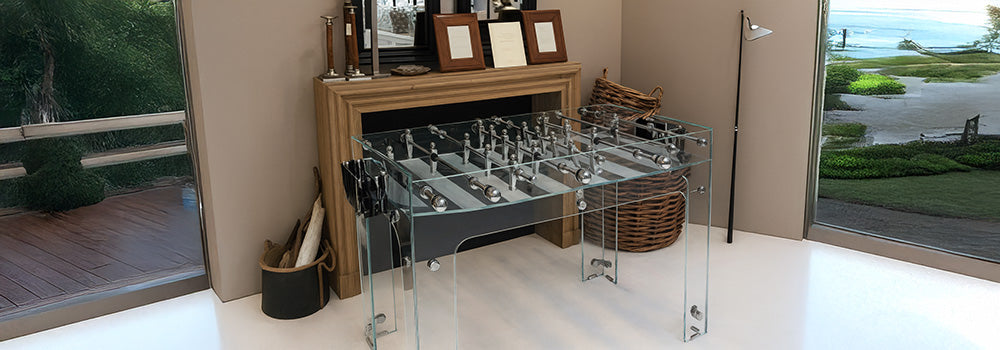 modern glass foosball table in a cozy room with wood mantel, wicker basket, and neutral tones.