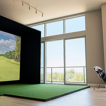 Bright apartment golf simulator with city view and wood floors.