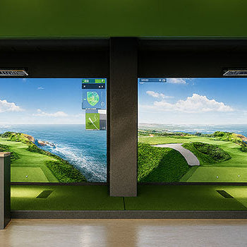 Dual golf simulator bays in a green-arched entertainment room with ocean view courses on screen.