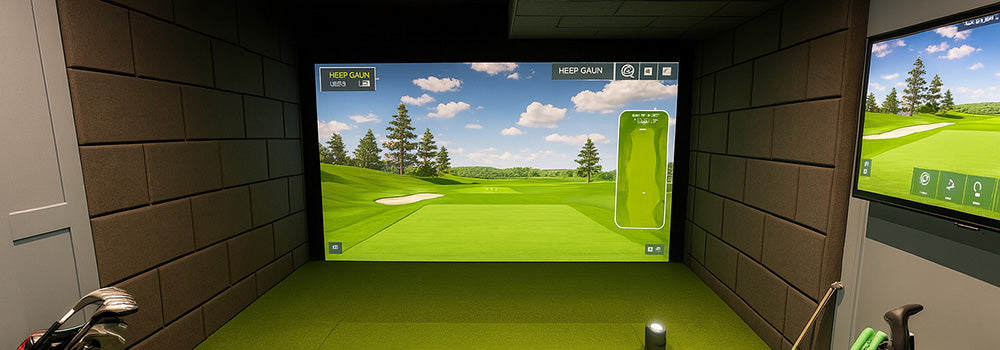 Indoor golf simulator room with green turf, dual screens, wall padding, and complete golf club set.