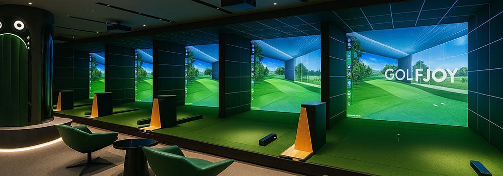 Stylish indoor golf simulator range with multiple projection bays, modern green chairs, and recessed lighting.