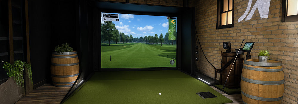 Rustic indoor golf simulator with wood flooring, barrel decor, and immersive course projection screen.