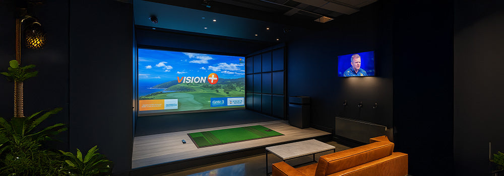 Stylish indoor golf simulator lounge with Vision+ display, leather seating, and dark modern interior.