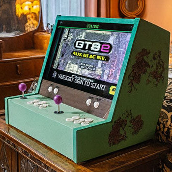 green arcade machine with purple joysticks on a carved wooden chest in a vintage bedroom with ornate furnishings and warm lighting.