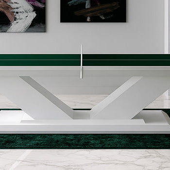 green luxury ping pong table with sculptural white base in a marble-floored study with abstract art and built-in shelves.