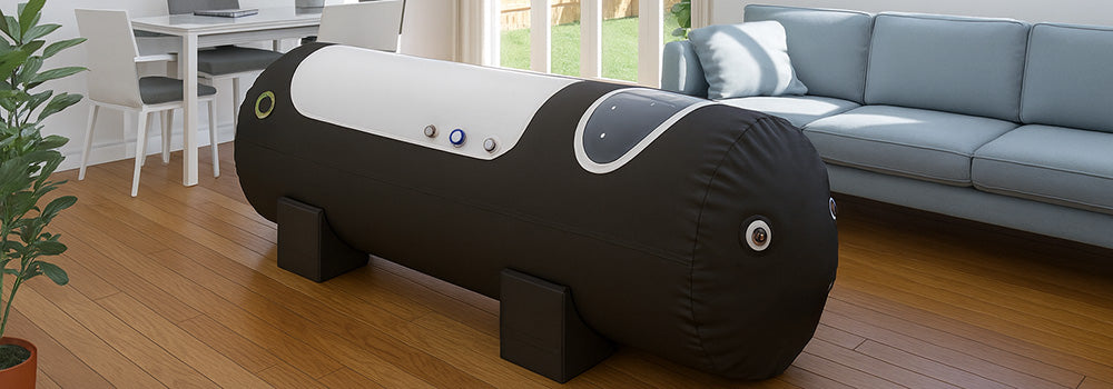 Hyperbaric oxygen chamber in a bright home interior with wood flooring, light blue sofa, and dining area, illuminated by natural light from garden-facing windows.