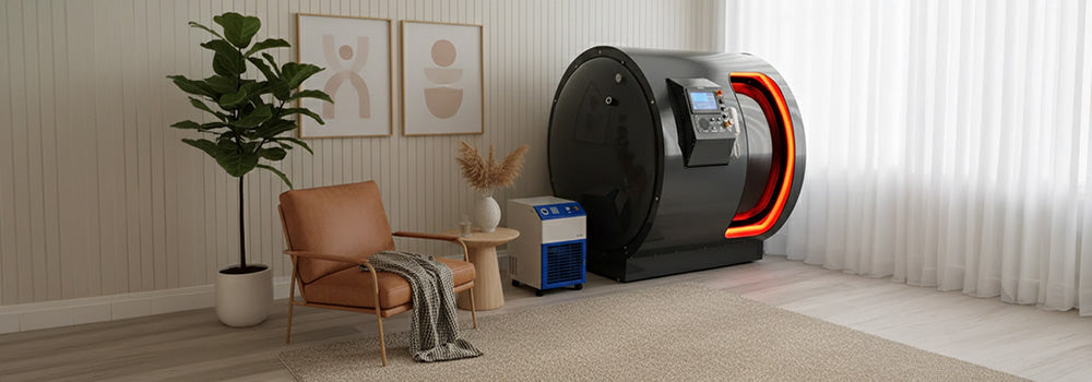 Hyperbaric oxygen chamber in a modern wellness treatment room with control units, clean white walls, and wood flooring.