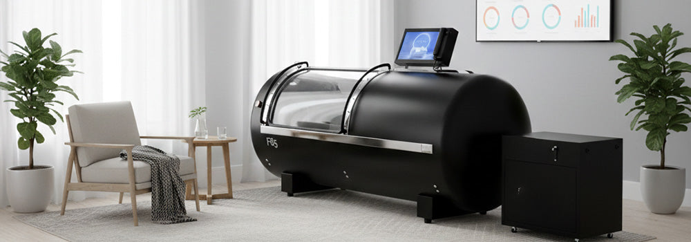 Hyperbaric oxygen therapy chamber in a private wellness room with beige walls, wood flooring, and connected oxygen units..