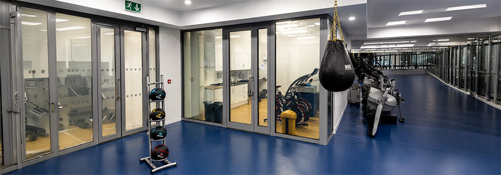 Hypoxic therapy and altitude training facility with exercise bikes, gym equipment and a glass-enclosed training room.