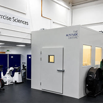 Hypoxic Therapy training room with cardio equipment behind glass and an AlterG anti-gravity treadmill in a modern rehabilitation facility.