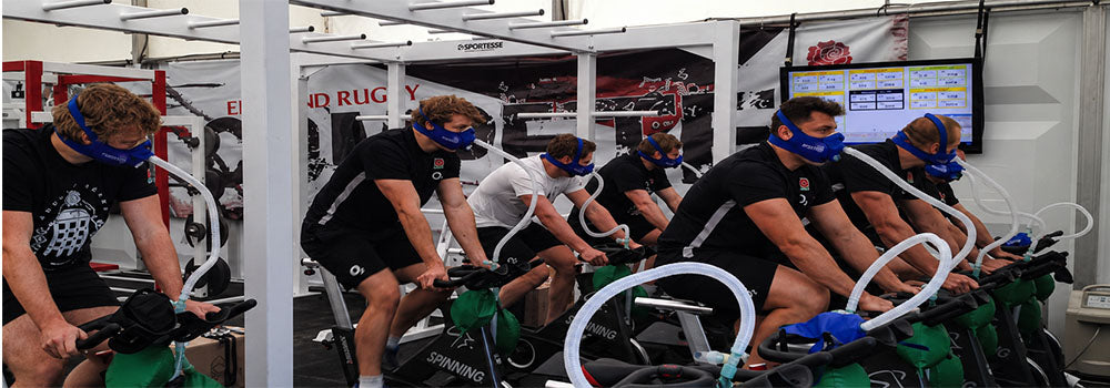 Athletes using Hypoxico breathing masks during treadmill and cycling exercises for simulated altitude, cardio and endurance training.