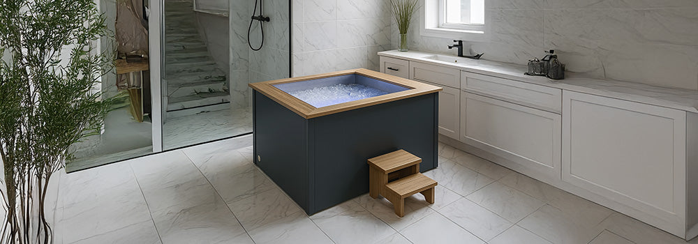 Modern indoor ice bath with wood trim in an elegant marble bathroom.
